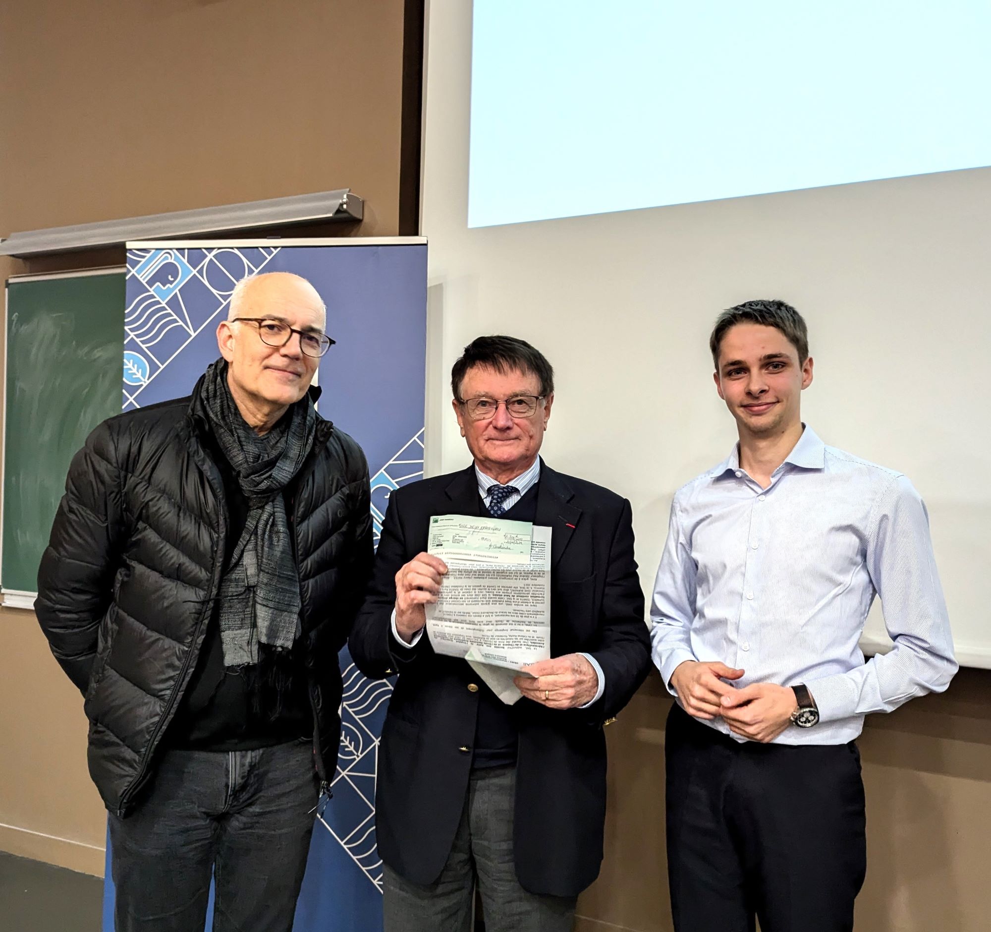 Laurent El Kaïm, directeur adjoint de la formation et de la recherche en charge de la recherche et René Couillandre, trésorier de la SAE, remettant le premier prix à Arthur Cabon